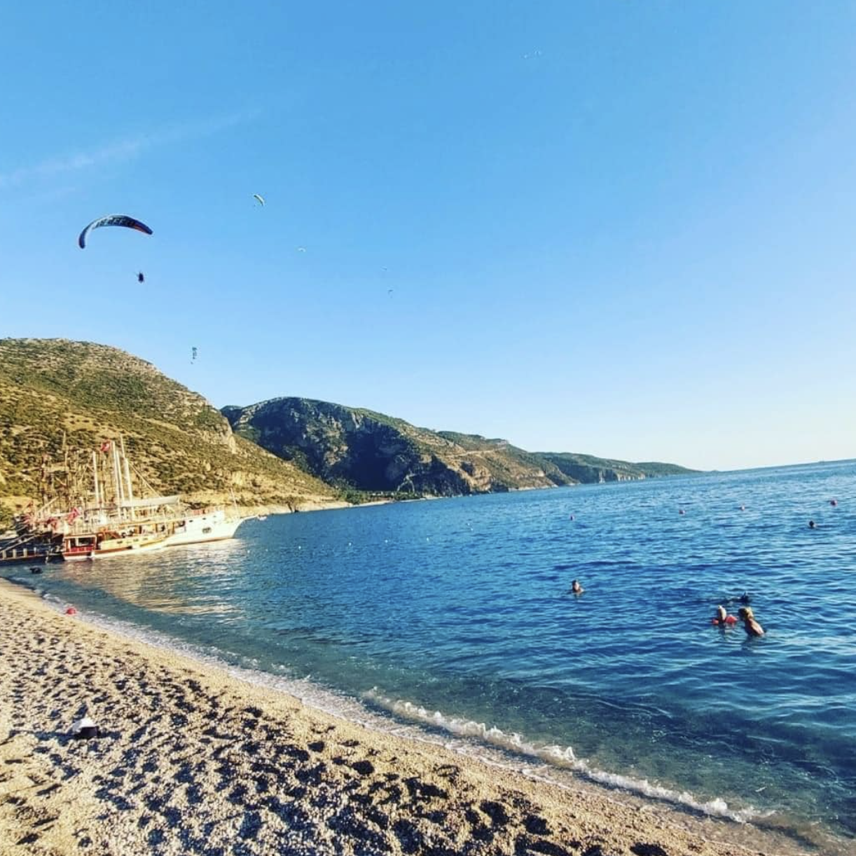 ფეტიეს სანაპირო, თურქეთი. ფონზე ზღვა, მთა და პარაშუტი.